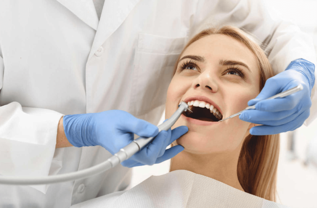 A dentist starting a common operation of cleaning the female teeth