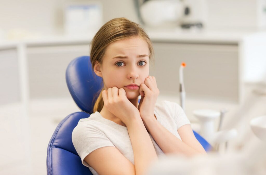 A young girl with anxiety about being at the dentist.