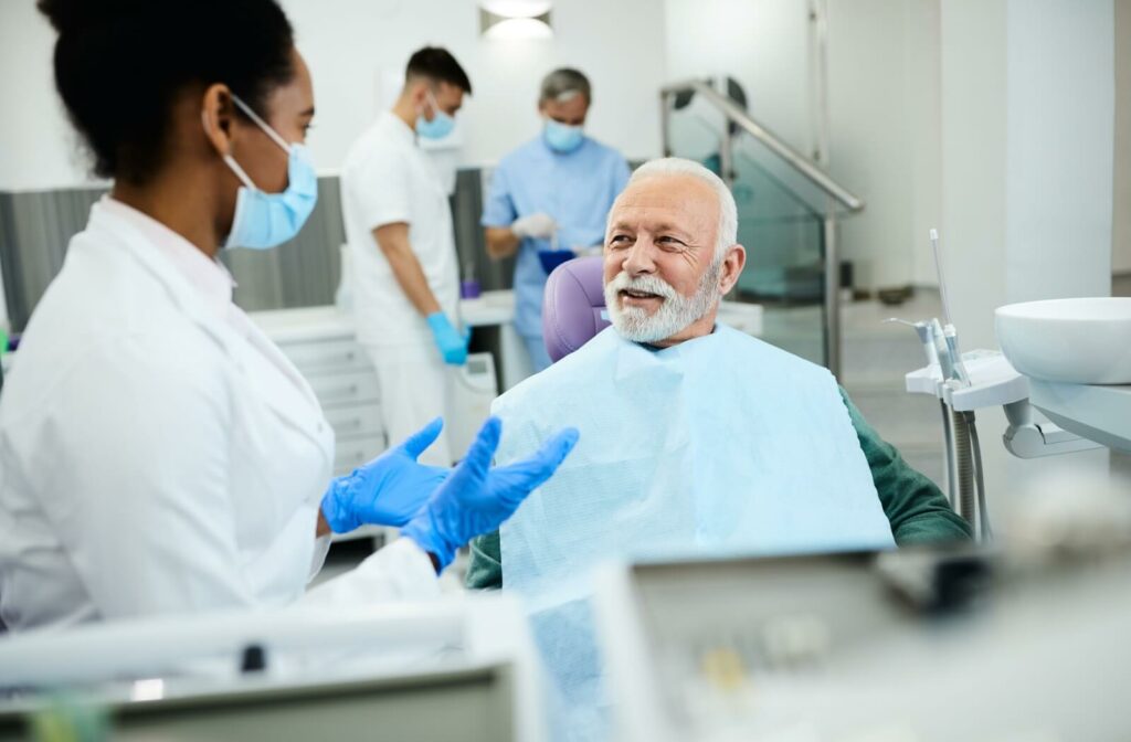 A young female dentist explaining to a senior patient what he can expect from his dentures.